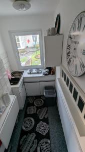 a small bathroom with a clock and a rug at Ferienwohnung Bergstraße Hammermühle in Bad Düben +2 photos