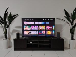 a flat screen tv sitting on a black entertainment center at QA Homestay in Tawau