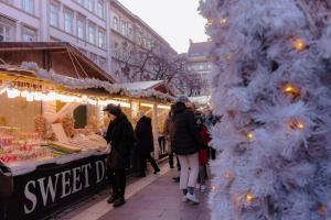 a group of people walking around a christmas market at Hotel Orion in Budapest