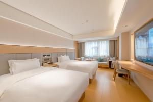 a hotel room with two beds and a flat screen tv at JI Hotel Guangzhou Ximenkou in Guangzhou