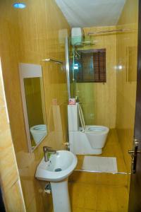 ein kleines Badezimmer mit Waschbecken und Toilette in der Unterkunft Triple Tee Hotel in Lagos + 28 Fotos