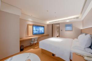 a hotel room with a bed and a tv at JI Hotel Guangzhou Ximenkou in Guangzhou