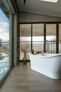 Dom w trawach في اوسترزوكي دولن: حوض استحمام في حمام به نافذة كبيرة