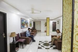 FabHotel Limewood في دهرادون: شخصان يجلسان في غرفة انتظار