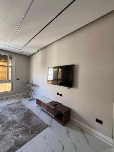 a living room with a flat screen tv on a wall at cozy flat in New Administrative Capital near European universities in Kafr ash Sharā‘inah