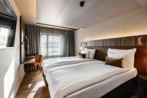 a hotel room with two beds and a window at Original Sokos Hotel Vaakuna Hämeenlinna in Hämeenlinna