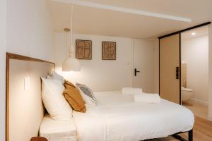 a bedroom with a bed with white sheets and pillows at L'Alma- Accès Privée-Proche Aéroport-Parking-Wifi in Achenheim +24 photos