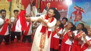 a group of people performing a performance on a stage at Eniye Takele Cultural House in Gonder