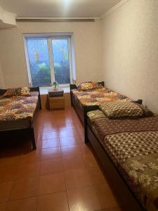 ein Zimmer mit drei Betten und einem Fenster in der Unterkunft Optimal 1 in Kiew