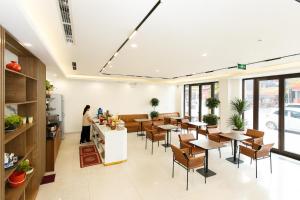 a restaurant with tables and chairs and a person in the background at The Sun Hotel Pho Co Ninh Binh in Ninh Binh +19 photos