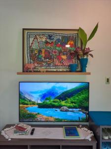 a flat screen tv sitting on top of a table at Casa Munti Garden Lodge in Daet