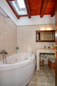 a bathroom with a white tub and a window at Spitaki traditional house in Vóroi +18 photos