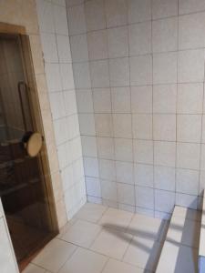 ein gefliestes Badezimmer mit Dusche und Glastür in der Unterkunft Optimal 1 in Kiew