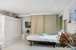 a white bedroom with a bed and a table at Tina Risager bed & breakfast in Sindal