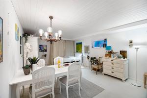 a dining room with a table and chairs and a bedroom at Tina Risager bed & breakfast in Sindal