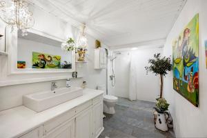 a white bathroom with a sink and a toilet at Tina Risager bed & breakfast in Sindal