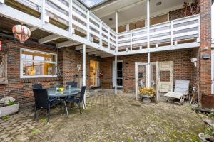 a patio with a table and chairs and a brick wall at Tina Risager bed & breakfast in Sindal