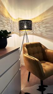 un salon avec une chaise et une lampe dans l'établissement Ferienwohnung Seelenruh, à Falkensee