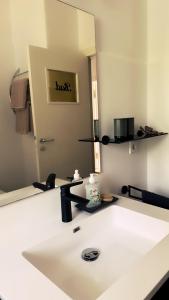 une salle de bains avec un lavabo et un miroir dans l'établissement Ferienwohnung Seelenruh, à Falkensee