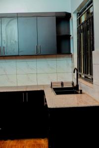 a kitchen with a sink and a counter at Happy Home House in Ruhengeri +20 photos