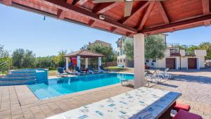 Beautiful Villa Grande with pool Island Krk في Gostinjac: حمام سباحة مع شرفة بجوار منزل