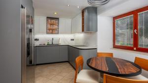 Beautiful Villa Grande with pool Island Krk في Gostinjac: مطبخ مع طاولة خشبية وغرفة طعام