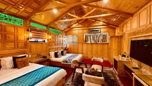 a train room with two beds and a tv at Kashmir Mahal Resorts by Stay Pattern in Srinagar +23 photos