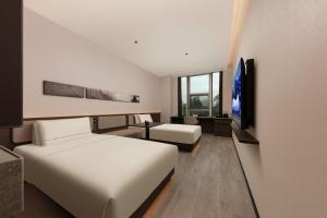 Atour Hotel Shanghai North Bund Riverside International Plaza في شانغهاي: غرفة فندق مع سرير وتلفزيون +67 صورة