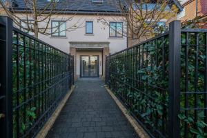 a hallway leading to a house with a fence at The Isleworth Garden Retreat 3BR 2BA with Gated Parking in Isleworth