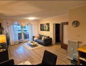 Hafenperle Ferienwohnung am Alten Stadthafen in Oldenburg - Zentrale City Lage في أولدنبورغ: غرفة معيشة بها أريكة وطاولة