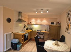 Hafenperle Ferienwohnung am Alten Stadthafen in Oldenburg - Zentrale City Lage في أولدنبورغ: مطبخ مع دواليب خشبية وطاولة في الغرفة