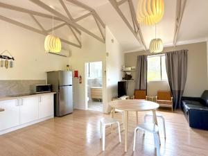a kitchen and a living room with a table and chairs at Beachside Cabin No 2 at Island Beach in Island Beach