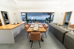 a dining room and living room with a table and chairs at Arama Villa by Swarga Mauritius in Cap Malheureux