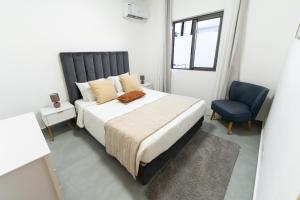 a bedroom with a bed and a blue chair at Arama Villa by Swarga Mauritius in Cap Malheureux +19 photos