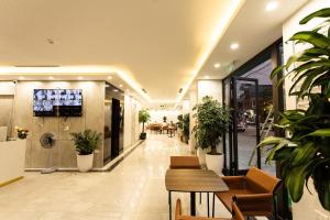 a lobby with potted plants in a building at The Sun Hotel Pho Co Ninh Binh in Ninh Binh