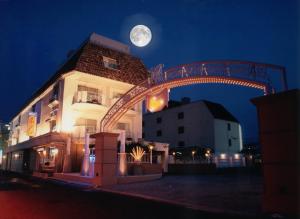 a moon rises behind a building with a bridge at Hotel Fine Biwako I in Moriyama