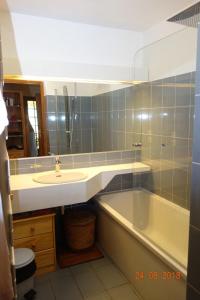 a bathroom with a sink and a bath tub at Appartement Les Balcons du Savoy in Chamonix-Mont-Blanc