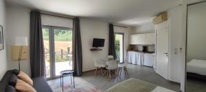 a living room with a couch and a table and a kitchen at Domaine équestre de la Chênaie in Saumur