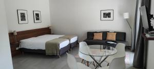 a bedroom with a bed and a glass table and chairs at Domaine équestre de la Chênaie in Saumur