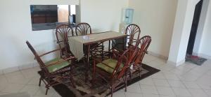 a dining room table and chairs in a room at Serena Beach Road Apartment in Mombasa