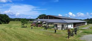 a building with a fence in front of a field at Domaine équestre de la Chênaie in Saumur