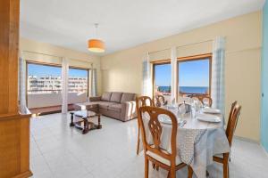 een eetkamer met een tafel en een bank bij Apartamentos Vista Mar in Armação de Pêra