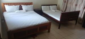 two twin beds in a room withskirts at Serena Beach Road Apartment in Mombasa