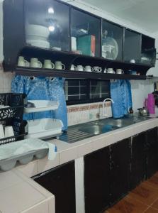 a kitchen with black and white cabinets and a sink at Besañes Homestay in Alaminos