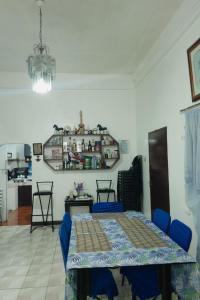 a dining room with a table and blue chairs at Besañes Homestay in Alaminos