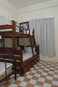 two bunk beds in a room with a checkered floor at Besañes Homestay in Alaminos