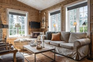 een woonkamer met een bank en een tafel bij Charming cabin in Hemsedal Golf Alpin - ideal for families, fishing & skiing in Granheim