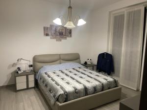 een slaapkamer met een bed en een kroonluchter bij Pino s house in Inveruno