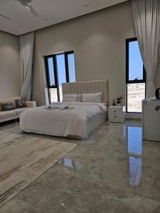 Un dormitorio con una cama y un sofá y ventanas. en فلة الشروق - Sunrise Villa, en Sur 31 fotos más