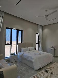 Un dormitorio con una cama grande y un sofá. en فلة الشروق - Sunrise Villa, en Sur